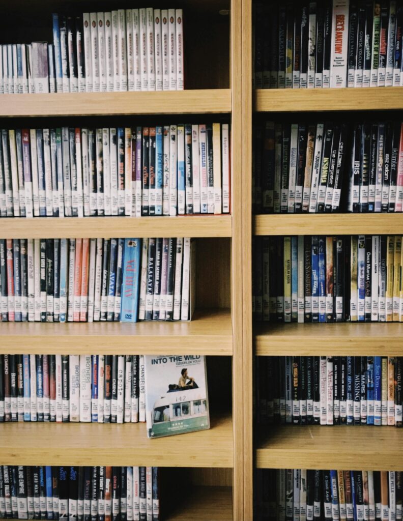 pexels photo 10680897 10680897 A close-up view of a bookshelf filled with diverse DVDs in a library setting.
